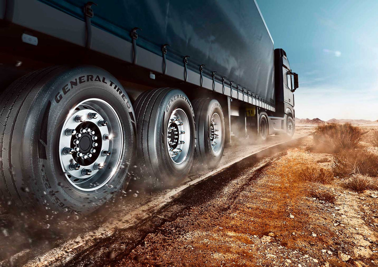 A imagem mostra uma carreta em um terreno agressivo de terra. O caminhão está equipado com pneus de carga da General Tire.