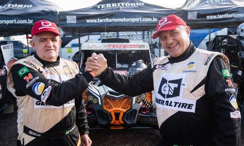 Imagem mostra Edu Piano e Solon Mendes, pilotos de rally, apertando as mãos e sorrindo para a foto. Nas vestimentas dos pilotos existe a presença da marca General Tire realçando o patrocínio na competição.